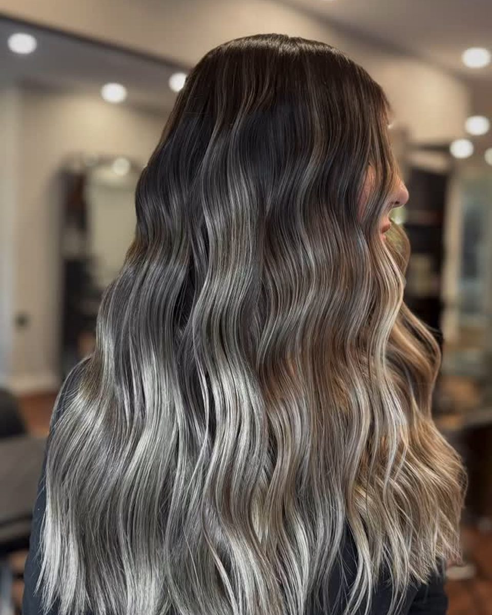 Balayage cendré sur base foncée, cheveux longs ondulés