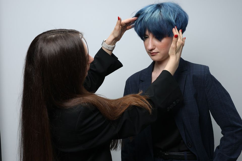 Iryna Skalozub ajuste la coupe courte bleue de son modèle en studio