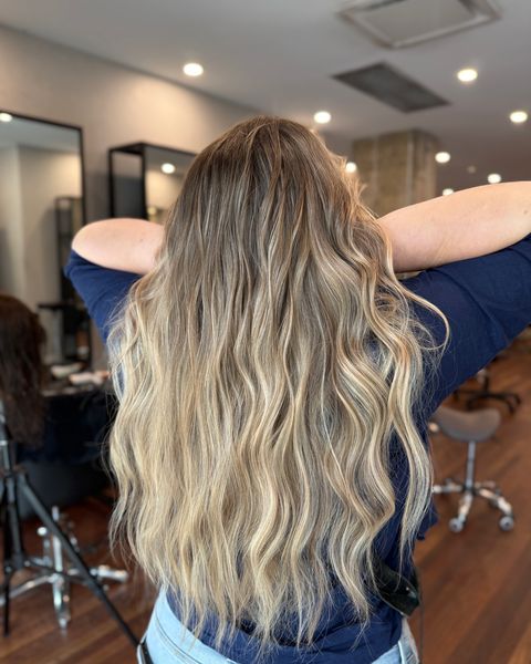 Balayage blond sur cheveux longs ondulés