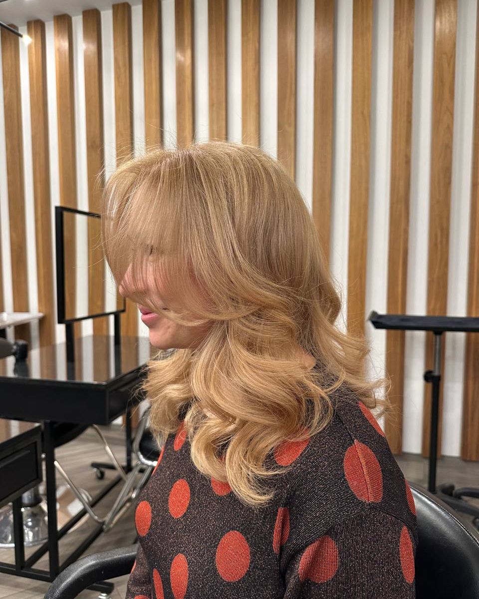 Frange rideau sur cheveux blonds bouclés